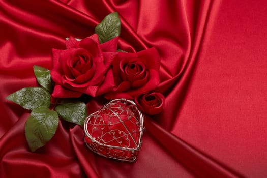Abstract background from red silk (satin), roses and heart. Fabric texture with draped. Top view with copy space. Element design. Valentine's day. Wedding day.  Women' s day. Greeting card