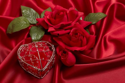 Abstract background from red silk (satin), roses and heart. Fabric texture with draped. Top view. Element design. Valentine's day. Wedding day.  Women' s day. Greeting card