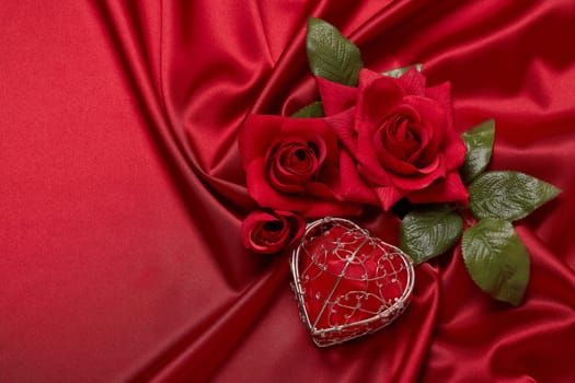 Abstract background from red silk (satin), roses and heart. Fabric texture with draped. Top view with copy space. Element design. Valentine's day. Wedding day.  Women' s day. Greeting card
