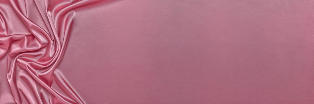 Abstract background from pink silk or satin. Luxury fabric texture with draped. Top view with copy space. Element design. Valentine's day.