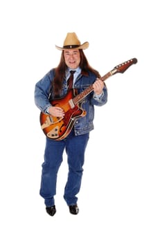 A handsome indigenous man in a jeans jacket, pants and a cowboy hat.standing and playing the guitar, isolated for white background.