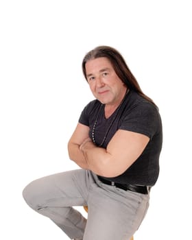 A middle age indigenous man in a portrait picture wearing a black.shirt and jewellery with his long hair, isolated for white background.