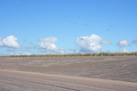 Dam at the Dutch North Sea coast, with blue sky in background