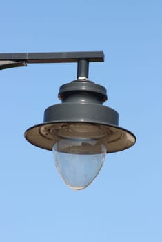 A decorated street lamp, blue sky in the background