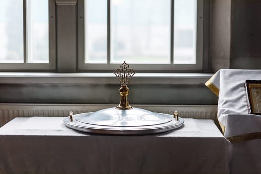 baptismal font cover lying in the church near the window