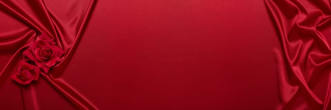Abstract background from red silk (satin) and roses. Fabric texture with draped. Top view with copy space. Element design. Valentine's day. Wedding day. Women' s day. Greeting card