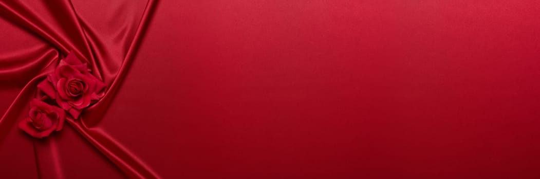 Abstract background from red silk (satin) and roses. Fabric texture with draped. Top view with copy space. Element design. Valentine's day. Wedding day. Women' s day. Greeting card