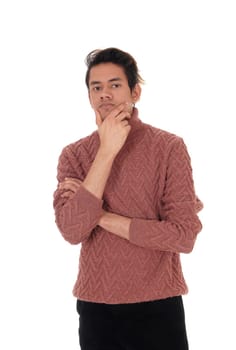 A tall young man standing in a burgundy sweater with one hand on .his chin thinking hard, isolated for white background.