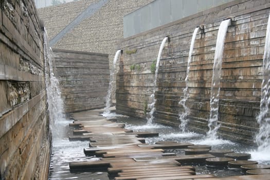 A way to a wall with water outflows over