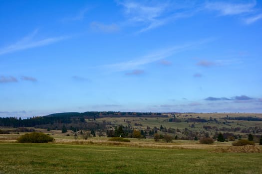 Green landscape  with big meadow, trees and blue sky in the Rhön, Bavaria, Germany