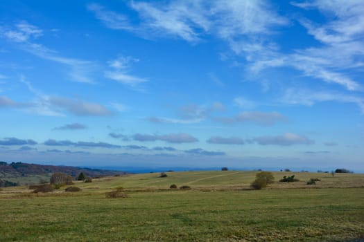 Green landscape  with big meadow, trees and blue sky in the Rhön, Bavaria, Germany with many copy space