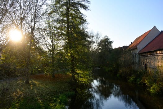 Small stream with nature and old houses in the evening light with sun  in Ostheim , Rhoen, Bavaria, Germany