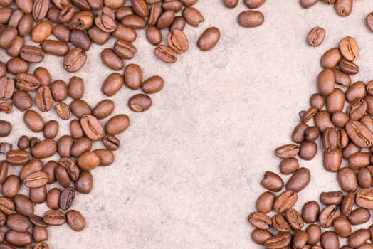 Roasted coffee beans on a brown textured background, empty space for text