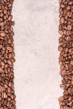 Roasted coffee beans on a brown textured background, empty space for text