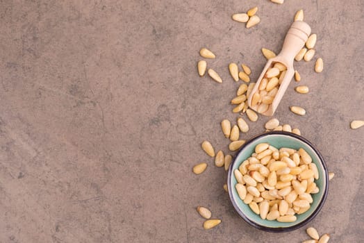 Pine nut seeds on a brown textured stone background, empty copy space