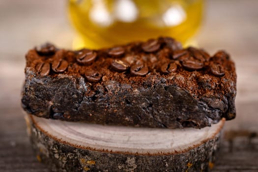 Handmade scrub soap on a wooden stand with ground coffee for relaxation and water treatments