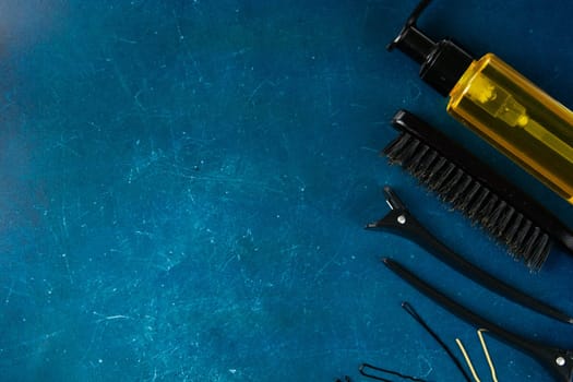 Haircut machines, nozzles of different sizes, combs and gels for styling, laid out on a beautiful black white striped background which stands on a gray wooden table. Clear space