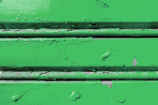 Background of old metal sheet with peel paint texture surface. Painted metal roller shutters door with peeling paint dirty green hue. Grungy background texture.
