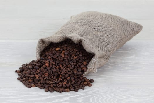 Coffee beans and hessian bag on wood surface