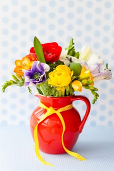 Bunch of colorful spring flowers in a little vase