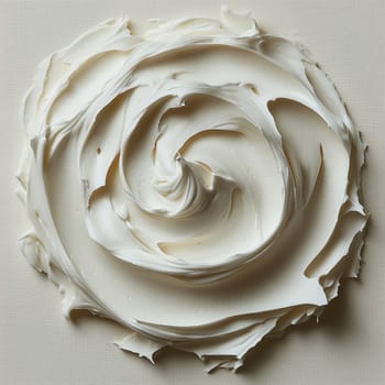 Artistic close-up of a thick, creamy white substance swirled into a circular pattern on a textured canvas, resembling paint, frosting, or skincare cream.