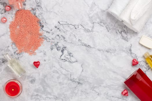 Spa still life with  toiletry, towel and  hearts on light  gray marble background. Top view with copy space. Healthy lifestyle, body care, Spa treatment. Valentine