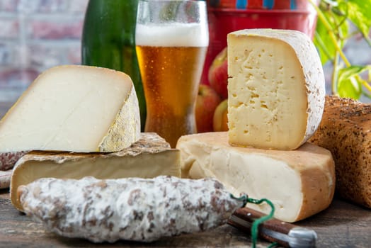 cheeses and Tomme de Savoie with a glass of beer, French cheese Savoy, french Alps France.
