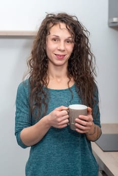 Lifestyle portrait of long haired beautiful girl holding a cup of tea
