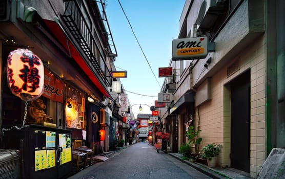 A golden commercial street in Tokyo's shinjuku district, where bars and restaurants are crammed with paper lanterns and illuminated signs illuminating the streets of Kabukicho.