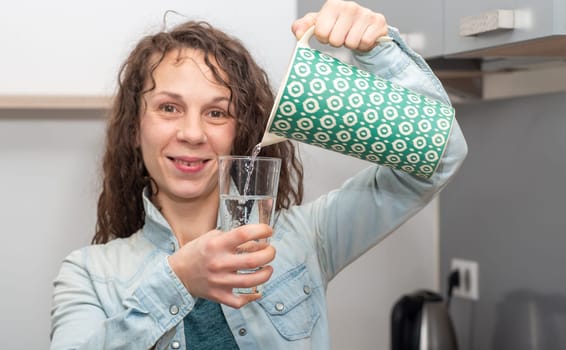 portrait of long haired beautiful woman pouring a glass of water