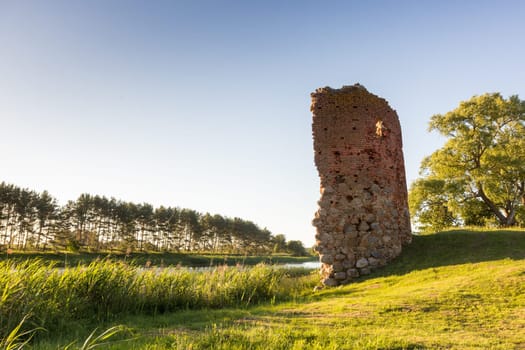 Old castle tower ruins in Latvia Piltene near river Venta