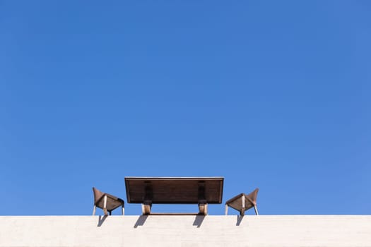 Chairs Table on edge of building outdoor in blue sky in abstract danger concept of trust integrity fraud .