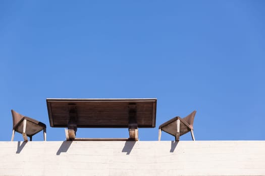 Chairs Table on edge of building outdoor in blue sky in abstract danger concept of trust integrity fraud .