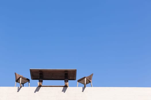 Chairs Table on edge of building outdoor in blue sky in abstract danger concept of trust integrity fraud .