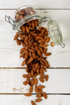 almonds with raisins dry in a glass jar on the wooden table