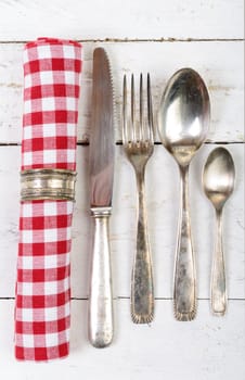 antique cutlery and towel on the white wooden table