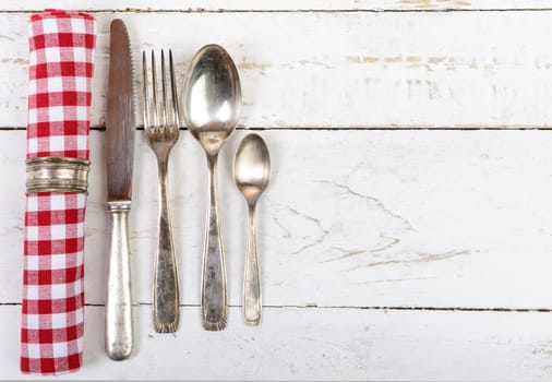 antique cutlery and towel on the white wooden table