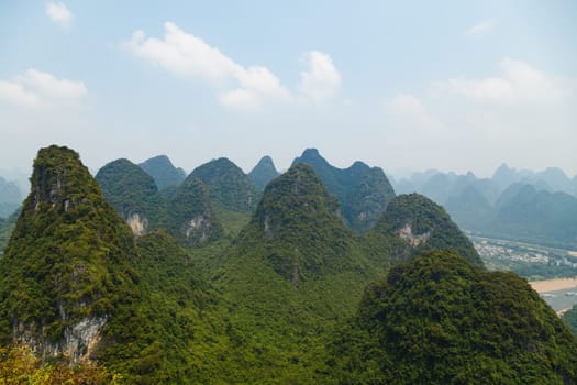 Picturesque mountains Yangshuo, Guilin, China on a sunny day with haze away