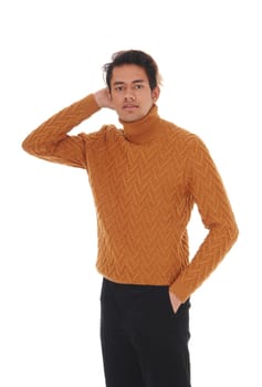 A tall skinny young man in black jeans and a yellow sweater.standing with one hand behind his head, isolated for white background.