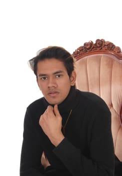 A close up image of a young good looking man in a black sweater .sitting in a armchair, isolated for white background.
