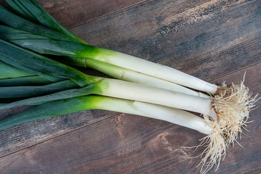 Fresh raw leeks on the wooden table