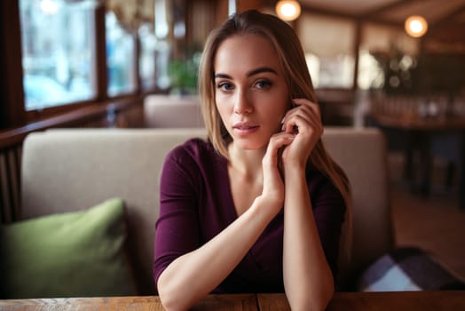 Young woman in a cafe or restaurant. Female waiting in cafe.