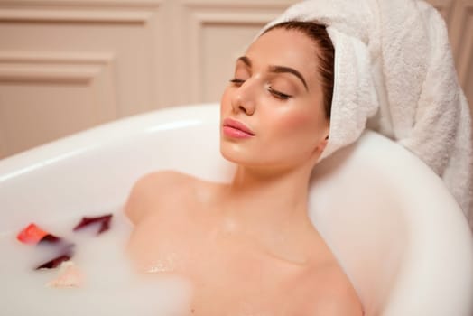 Beautiful woman in bathroom with rose petals.