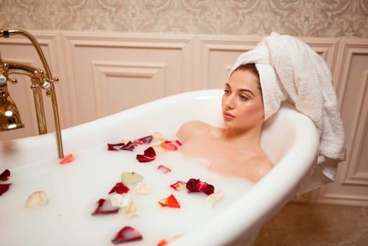 Beautiful woman in bathroom with rose petals.