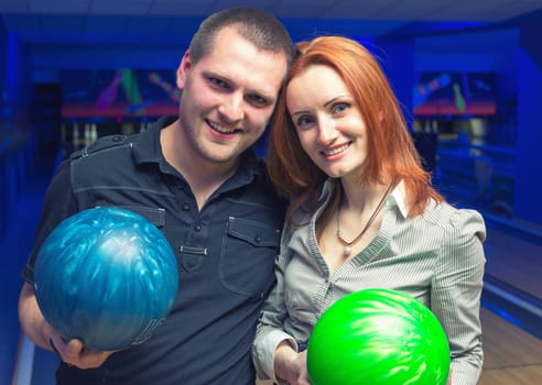 Happy couple in a bowling alley having fun