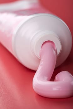 Pink toothpaste squeezing out of tube