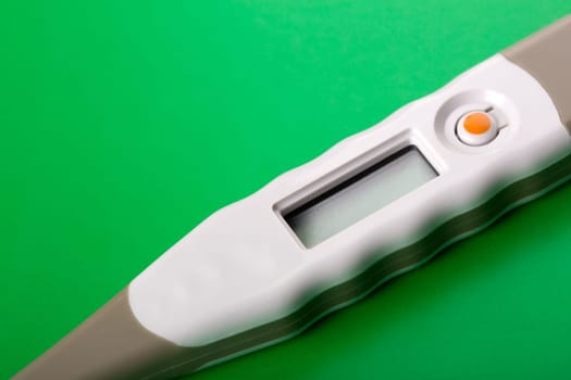 Closeup of digital thermometer on green