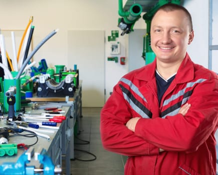 Portrait of happy mechanic at workroom