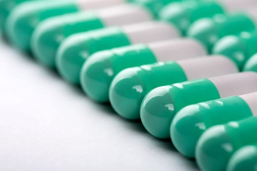 Closeup of green-white pills in a row