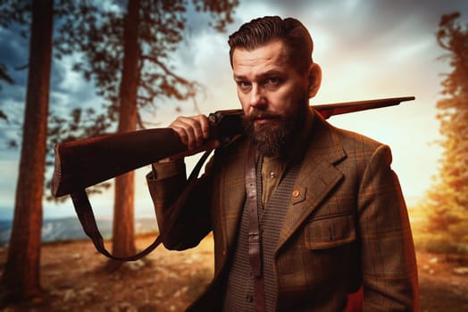 Hunter man in vintage hunting clothing with old gun, forest on background. Hunt lifestyle